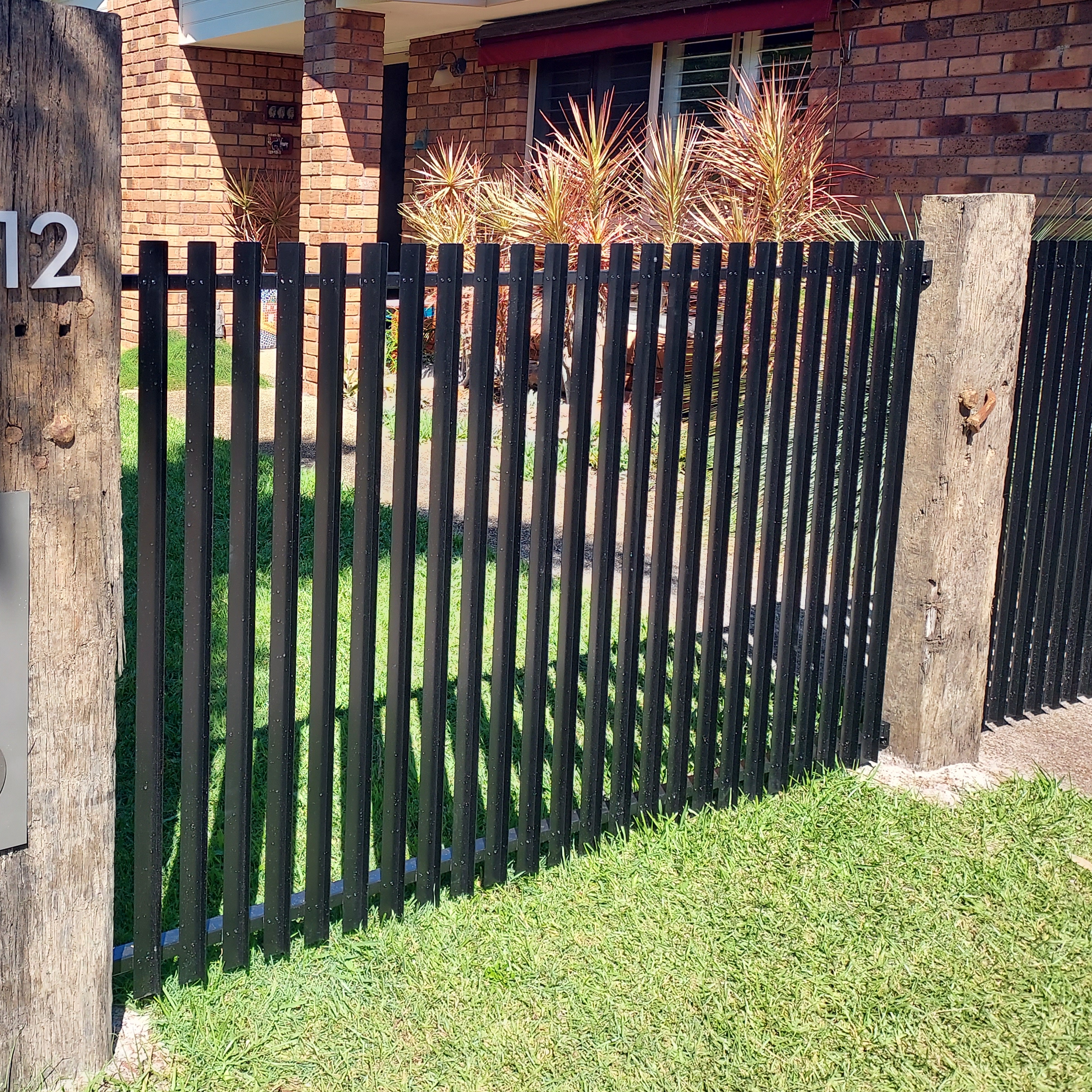 Does the flat side of the vertical slat fencing panels go onto the pool side inside or the outside?